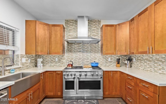 kitchen with decorative backsplash, sink, stainless steel appliances, and wall chimney range hood