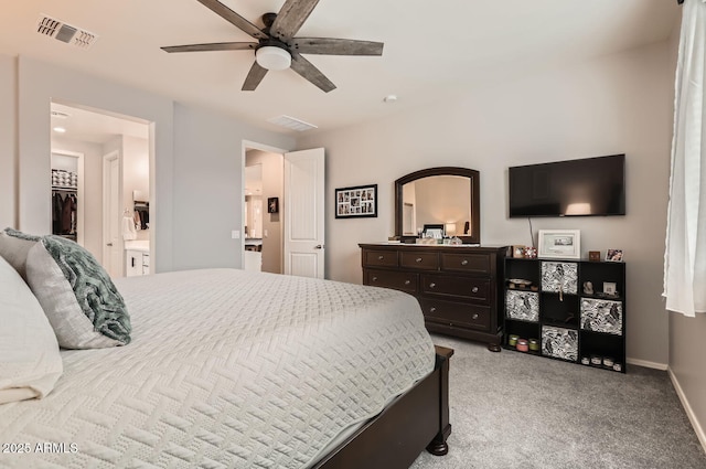 bedroom with a walk in closet, visible vents, a ceiling fan, light carpet, and baseboards