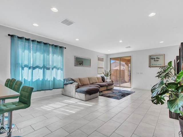 living area with recessed lighting, light tile patterned floors, visible vents, and baseboards