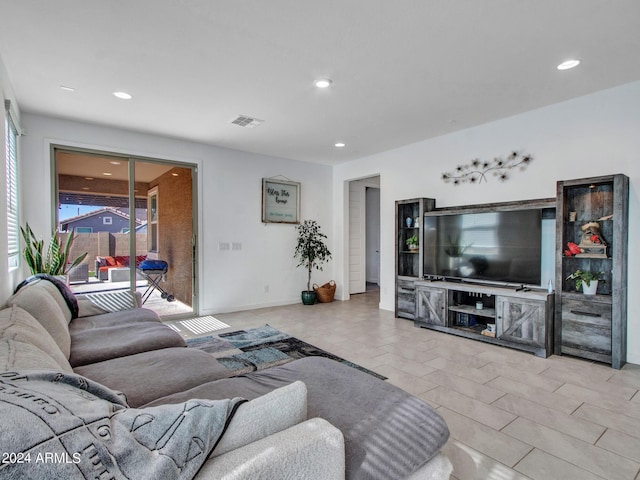 living area with baseboards, visible vents, and recessed lighting
