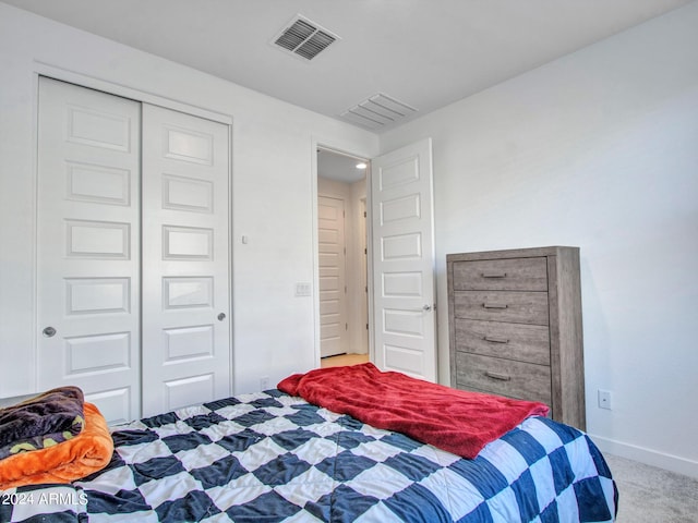 bedroom with visible vents, baseboards, carpet flooring, and a closet