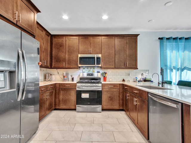 kitchen with a sink, light countertops, tasteful backsplash, and stainless steel appliances