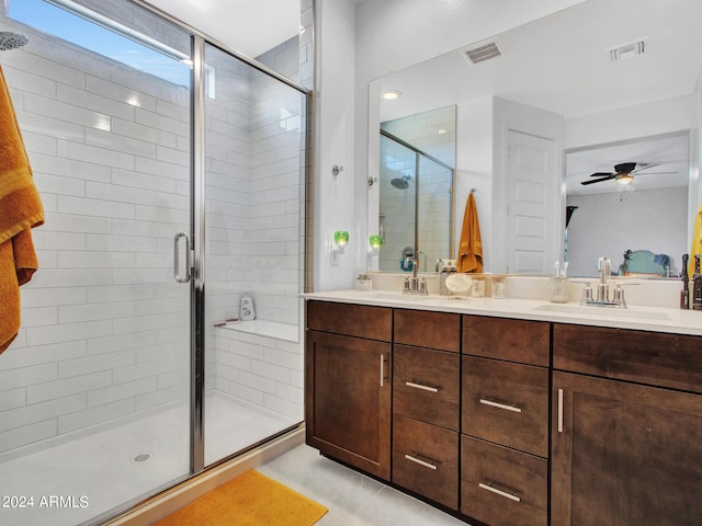 bathroom with visible vents, a sink, a ceiling fan, a shower stall, and double vanity