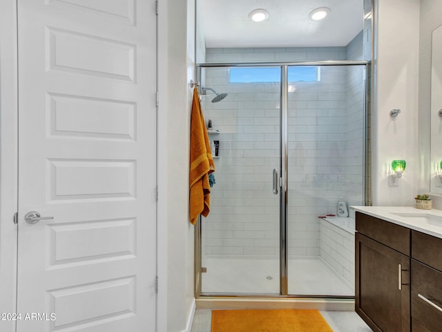 bathroom featuring vanity and a shower with shower door