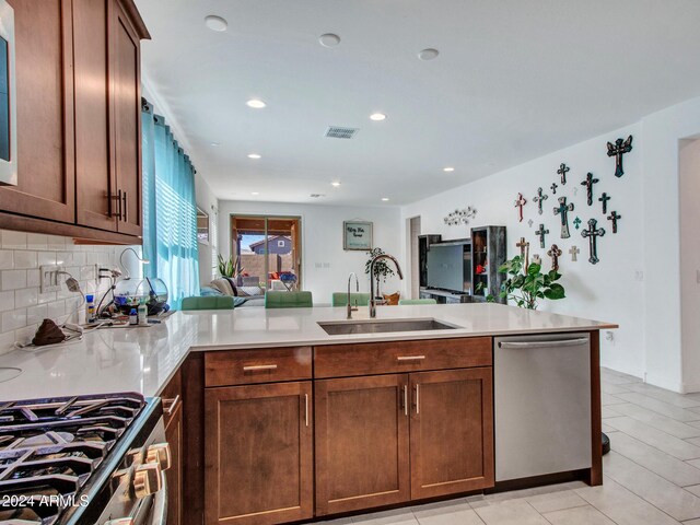 kitchen with visible vents, a sink, light countertops, a peninsula, and stainless steel dishwasher