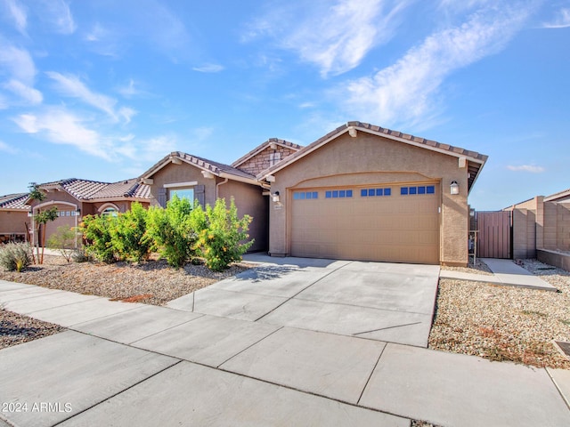 single story home with a garage, fence, stucco siding, a gate, and driveway
