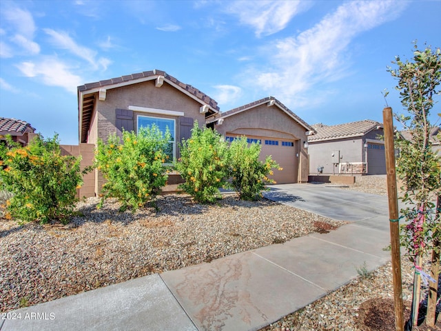 view of front of property featuring an attached garage, a tiled roof, driveway, and stucco siding
