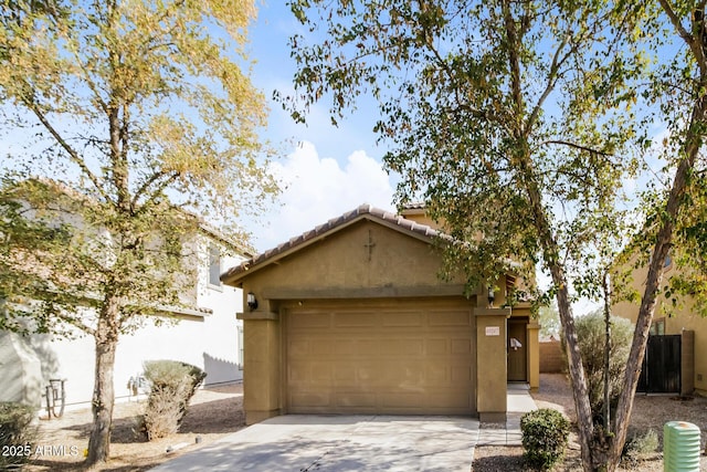 view of front of home with an outbuilding, a tile roof, stucco siding, a garage, and driveway