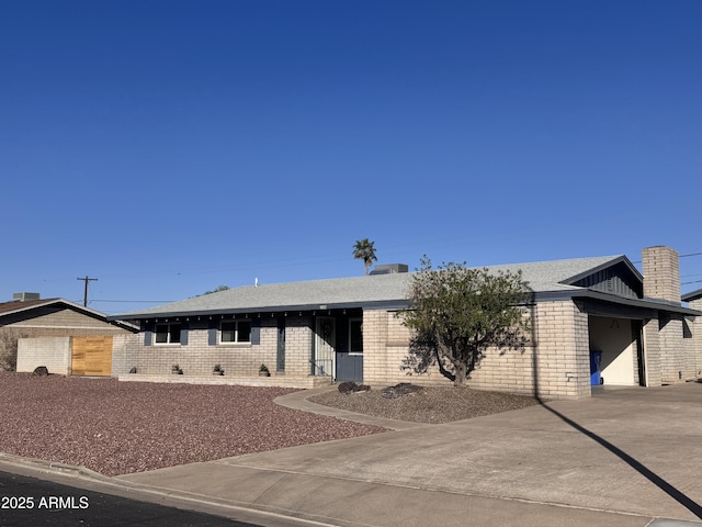 single story home with a garage, brick siding, and concrete driveway