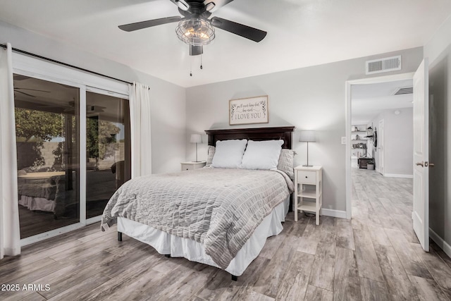 bedroom with access to outside, visible vents, baseboards, and wood finished floors