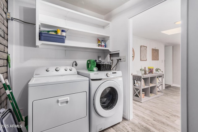 washroom with laundry area, light wood-type flooring, and separate washer and dryer