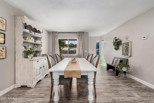 dining room with baseboards and wood finished floors