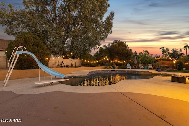15011 N 45th Pl, Phoenix, AZ 85032 - pool at dusk featuring a water slide and a patio area