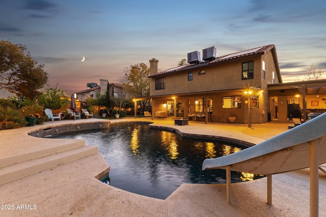 15011 N 45th Pl, Phoenix, AZ 85032 - pool at dusk featuring a patio, a water slide, and cooling unit