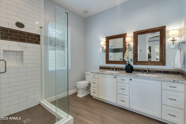 bathroom featuring vanity, hardwood / wood-style flooring, toilet, and walk in shower