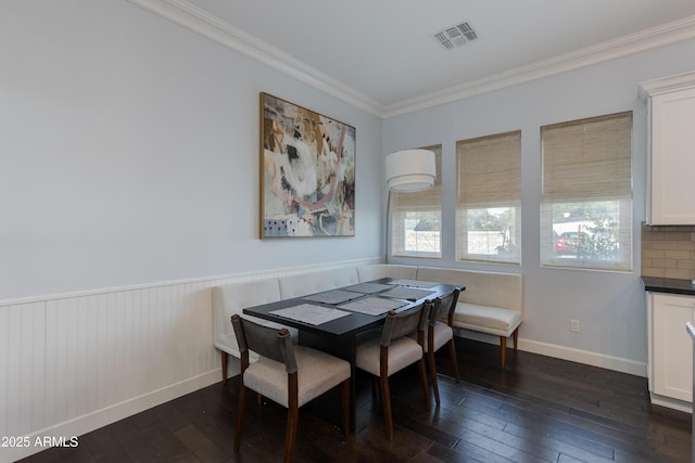 dining room with dark hardwood / wood-style flooring and ornamental molding