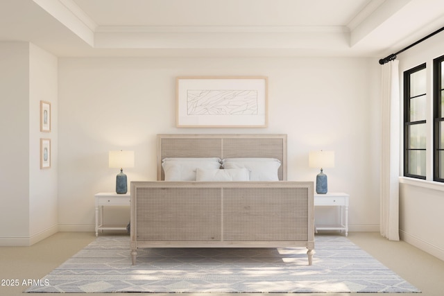 bedroom with crown molding, a raised ceiling, and baseboards