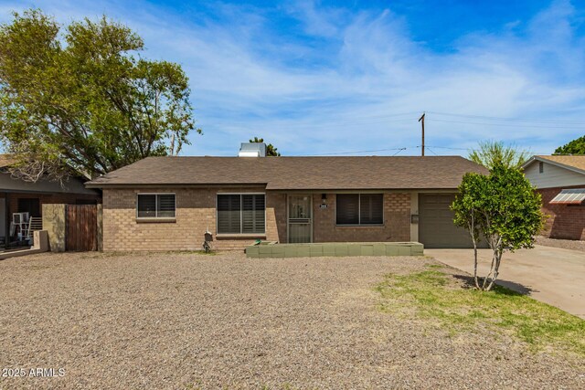 2808 W Lawrence Rd, Phoenix, AZ 85017 - ranch-style house featuring roof with shingles, brick siding, a chimney, a garage, and concrete driveway