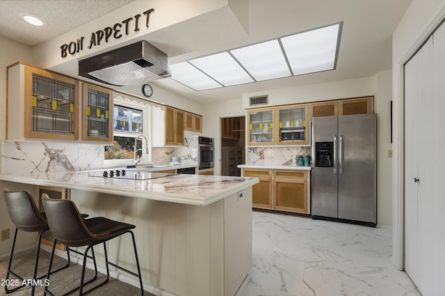 kitchen featuring stainless steel appliances, a kitchen breakfast bar, decorative backsplash, and kitchen peninsula