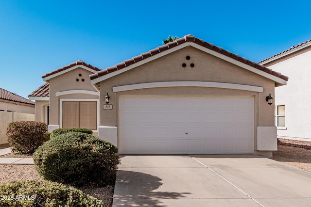 mediterranean / spanish home featuring a garage, concrete driveway, and stucco siding