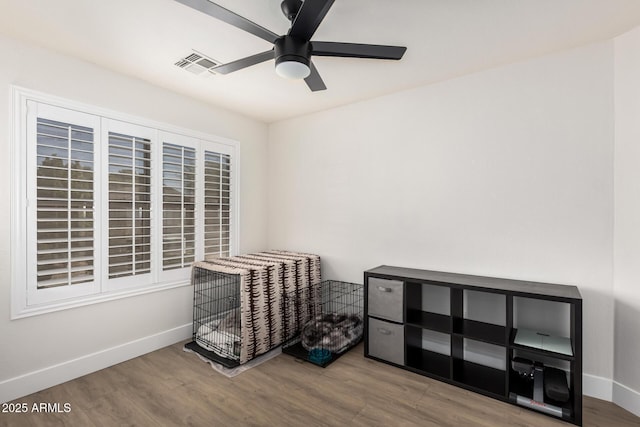 miscellaneous room featuring a ceiling fan, wood finished floors, visible vents, and baseboards