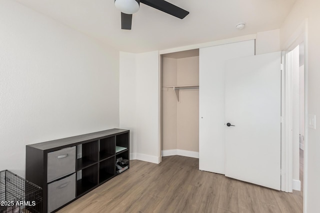 bedroom with baseboards, a closet, a ceiling fan, and wood finished floors