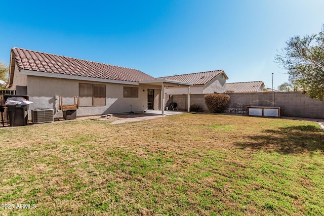 rear view of property featuring a lawn, a patio area, a fenced backyard, and stucco siding