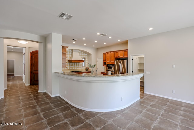 kitchen featuring kitchen peninsula, decorative backsplash, dark tile patterned floors, and appliances with stainless steel finishes