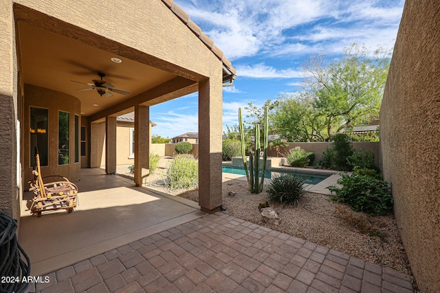 view of patio / terrace with a fenced in pool and ceiling fan