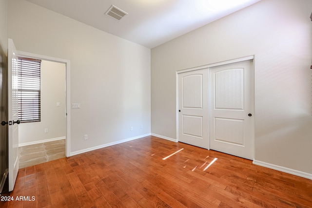 unfurnished bedroom with hardwood / wood-style floors and a closet