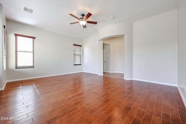 empty room with dark hardwood / wood-style floors and ceiling fan