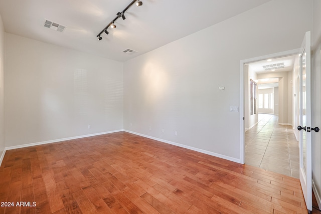 unfurnished room with light wood-type flooring and track lighting