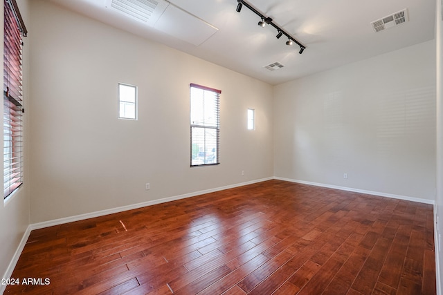 unfurnished room featuring dark hardwood / wood-style flooring and rail lighting