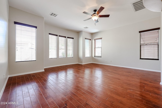 empty room with dark hardwood / wood-style floors and ceiling fan