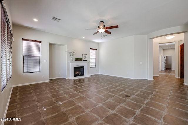 25995 N 85th Dr, Peoria, AZ 85383 - unfurnished living room featuring ceiling fan, baseboards, recessed lighting, and a glass covered fireplace