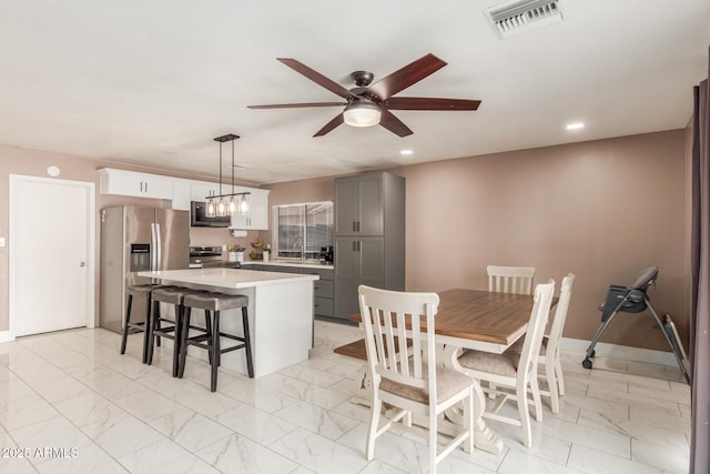 dining area featuring ceiling fan with notable chandelier