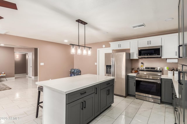 kitchen featuring white cabinets, a kitchen island, gray cabinetry, and appliances with stainless steel finishes