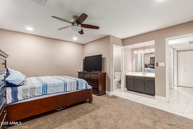 bedroom featuring ensuite bathroom, light tile patterned flooring, sink, and ceiling fan