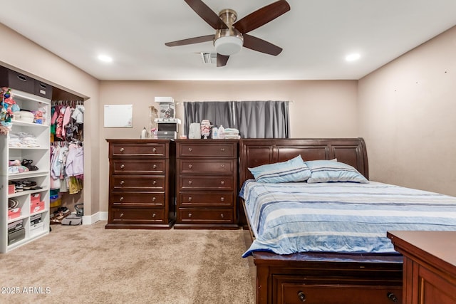 bedroom with ceiling fan, light colored carpet, and a closet