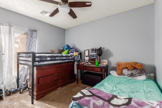 carpeted bedroom featuring a textured ceiling and ceiling fan