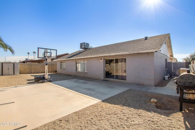 rear view of house with central air condition unit, a patio, and a shed