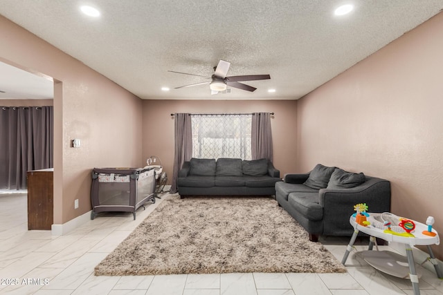 living room featuring a textured ceiling and ceiling fan