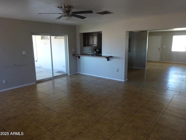 3171 W Orchid Ln, Phoenix, AZ 85051 - unfurnished living room with a ceiling fan, dark tile patterned flooring, and baseboards