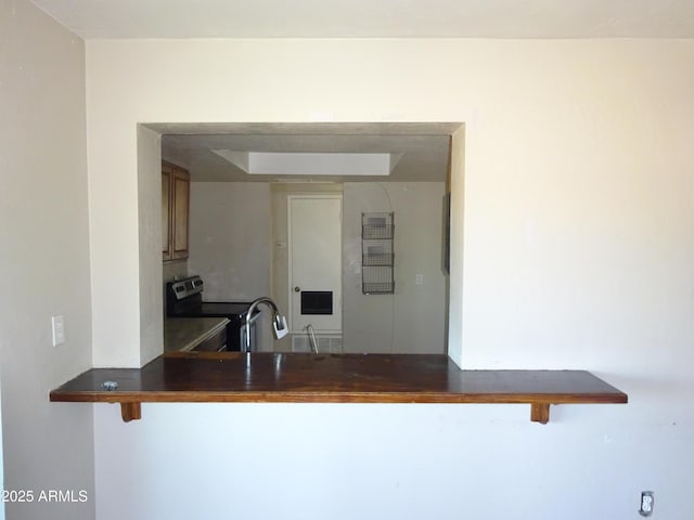 3171 W Orchid Ln, Phoenix, AZ 85051 - kitchen featuring stainless steel electric range oven, dark countertops, a breakfast bar, and a sink