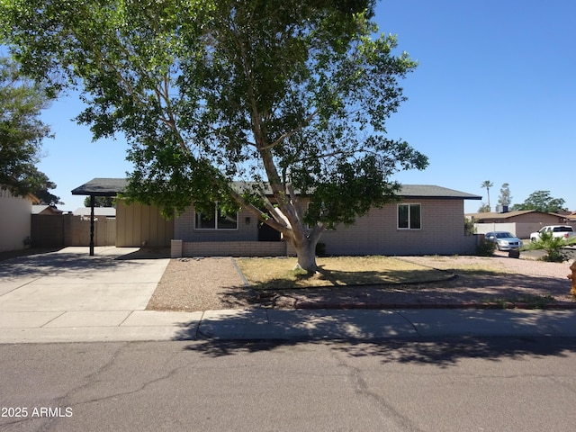 3171 W Orchid Ln, Phoenix, AZ 85051 - view of front of home featuring brick siding, a carport, driveway, and fence