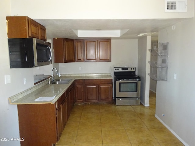 3171 W Orchid Ln, Phoenix, AZ 85051 - kitchen with stainless steel appliances, a sink, light countertops, light tile patterned floors, and baseboards