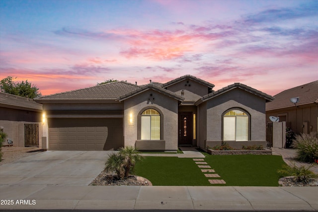 mediterranean / spanish-style home with a lawn and a garage