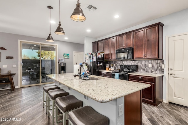 291 N Scott Dr, Chandler, AZ 85225 - kitchen with decorative backsplash, visible vents, a kitchen island with sink, wood finished floors, and black appliances