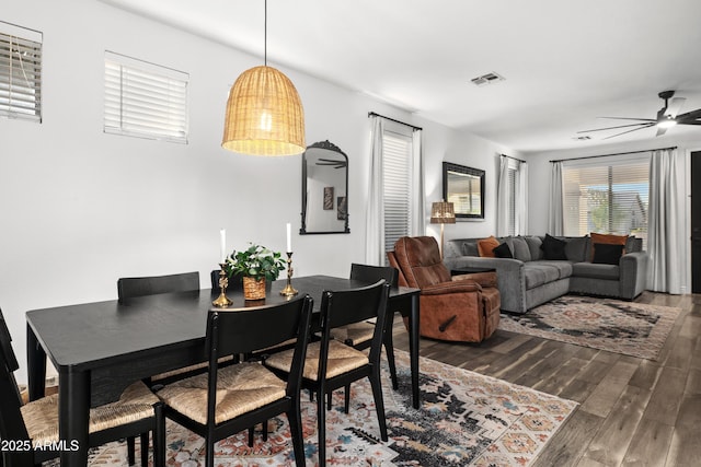 dining area featuring ceiling fan, visible vents, and dark wood finished floors