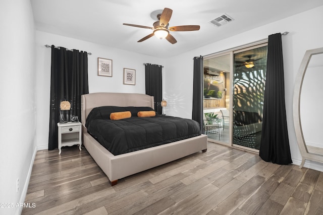 bedroom featuring visible vents, wood finished floors, access to exterior, baseboards, and a ceiling fan